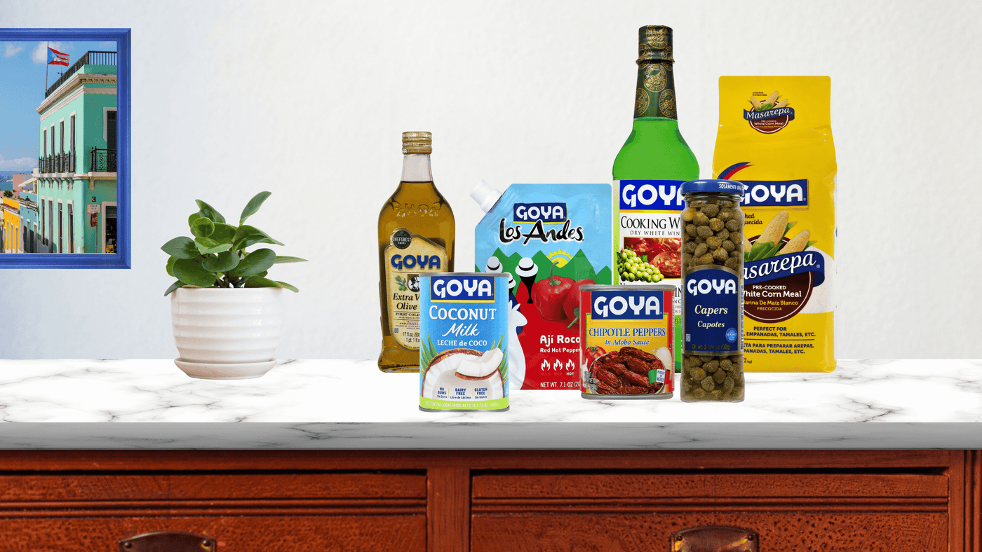 Various Goya products on table top with a pot of plant and wall art next to it
