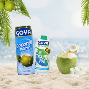 various Goya coconut water next to coconut on the beach